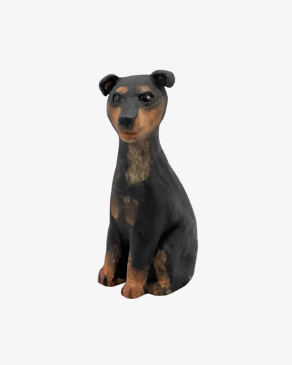 Liten svart och tan hundskulptur